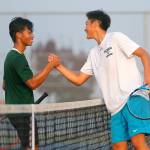 Lee (right) and senior teammate Austen Lim congratulate each other after the district singles final. (Ryan Berry / The Herald)
