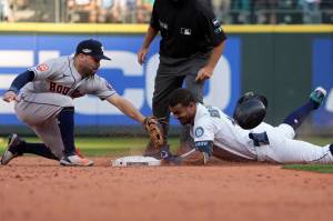 Seattle Mariners' Julio Rodriguez (44) slides safely into second base for a double under Houston Astros second baseman Jose Altuve during the eighth inning in Game 3 of an American League Division Series baseball game Saturday, Oct. 15, 2022, in Seattle. (AP Photo/Ted S. Warren)