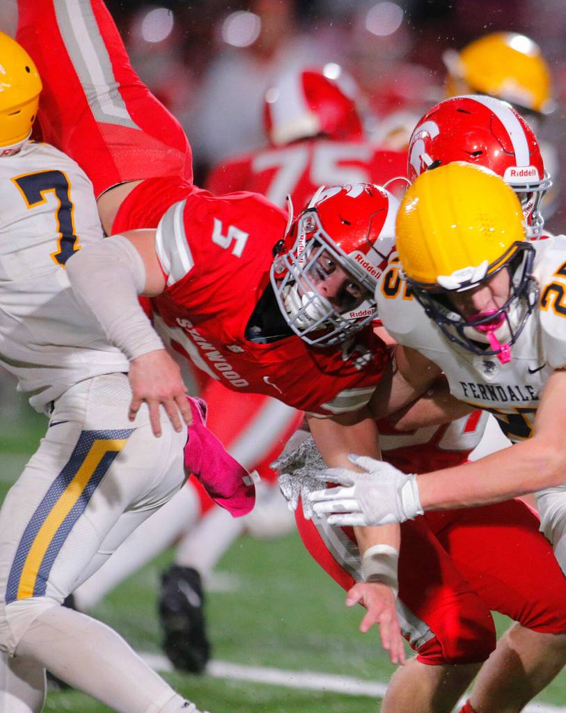 Stanwoods Ryder Bumgarner loses the ball as he gets flipped completely upside down during a carry against Ferndale Friday, Oct. 21, 2022, at Stanwood High School in Stanwood, Washington. Stanwood recovered the ball. (Ryan Berry / The Herald)