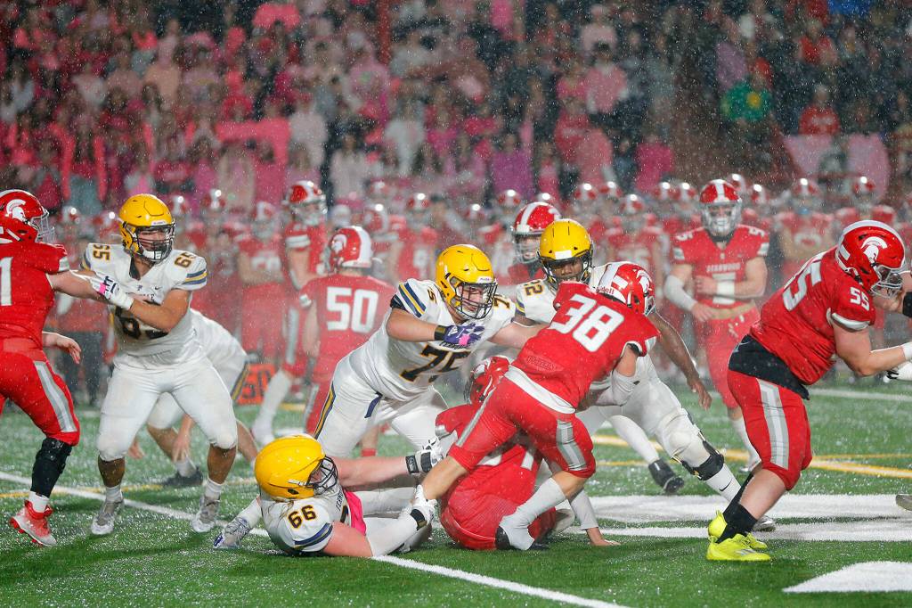 Stanwoods Carson Beckt fights for extra yards as the rain comes down against Ferndale Friday, Oct. 21, 2022, at Stanwood High School in Stanwood, Washington. (Ryan Berry / The Herald)