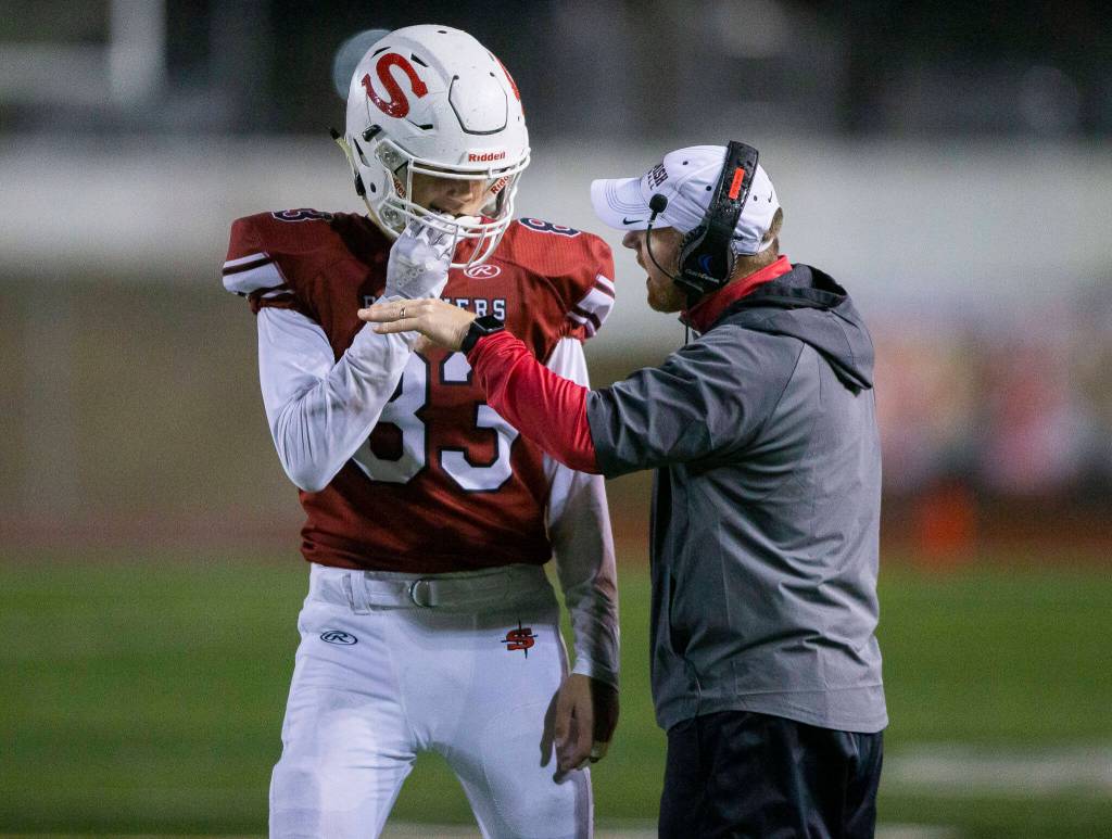 Snohomish head coach Joey Hammer speaks with Louis Miller during a game against Monroe on Friday, Oct. 21, 2022 in Snohomish, Washington. (Olivia Vanni / The Herald)