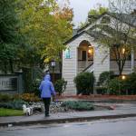 A woman walks her dog past Olin Fields Apartments, one of Security Properties Residentials complexes in Snohomish County, on Tuesday, in Everett. (Ryan Berry / The Herald)