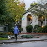 A woman walks her dog past Olin Fields Apartments, one of Security Properties Residential’s complexes in Snohomish County, on Tuesday, Oct. 25, 2022, in Everett, Washington. (Ryan Berry / The Herald)