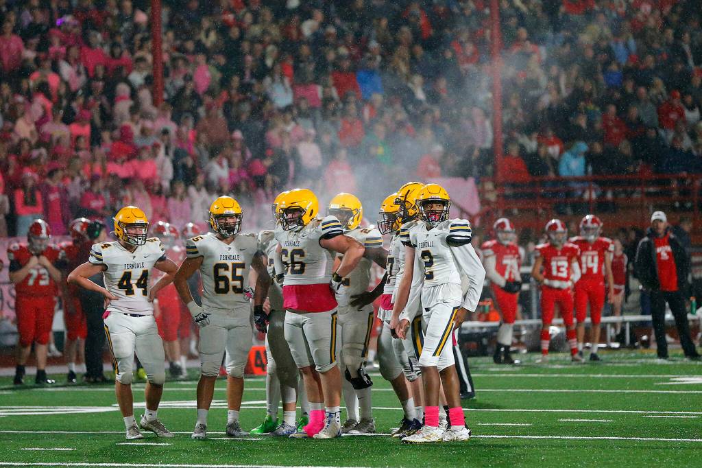 Steam rises into the air above the Ferndale offense as they huddle during a game against Stanwood on Oct. 21 in Stanwood. (Ryan Berry / The Herald)