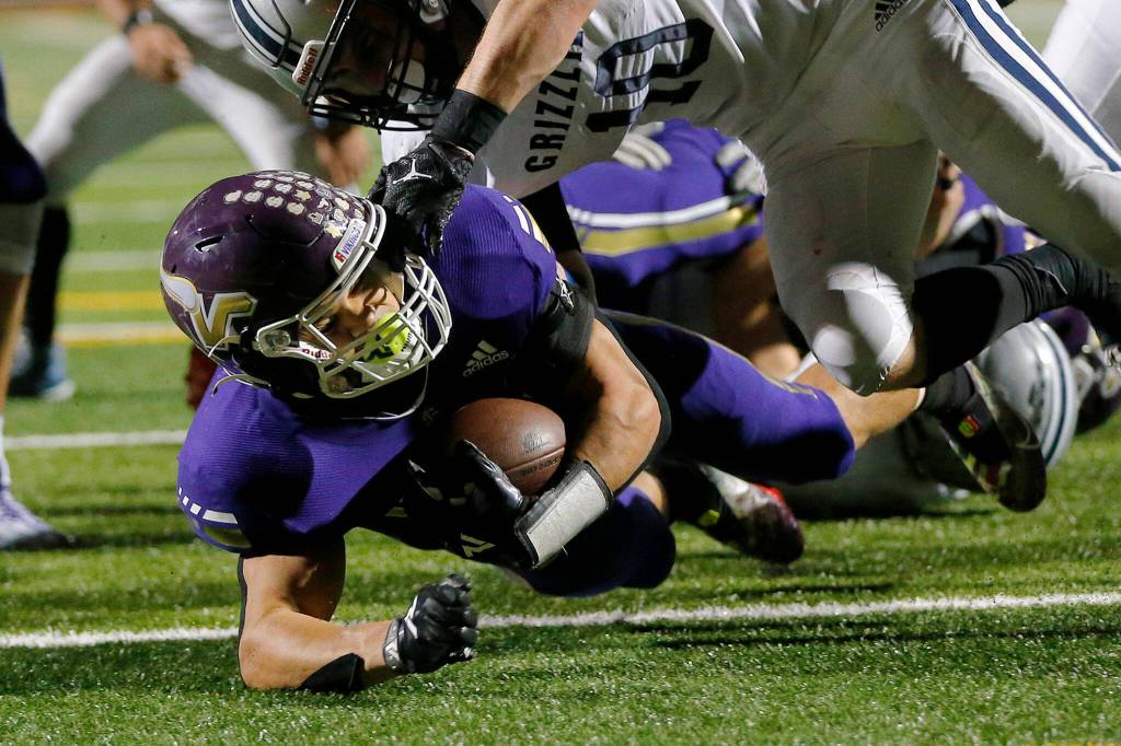 Lake Stevens Jayden Limar punches the ball into the end zone against Glacier Peak on Friday, Oct. 28, 2022, at Lake Stevens High School in Lake Stevens, Washington. (Ryan Berry / The Herald)