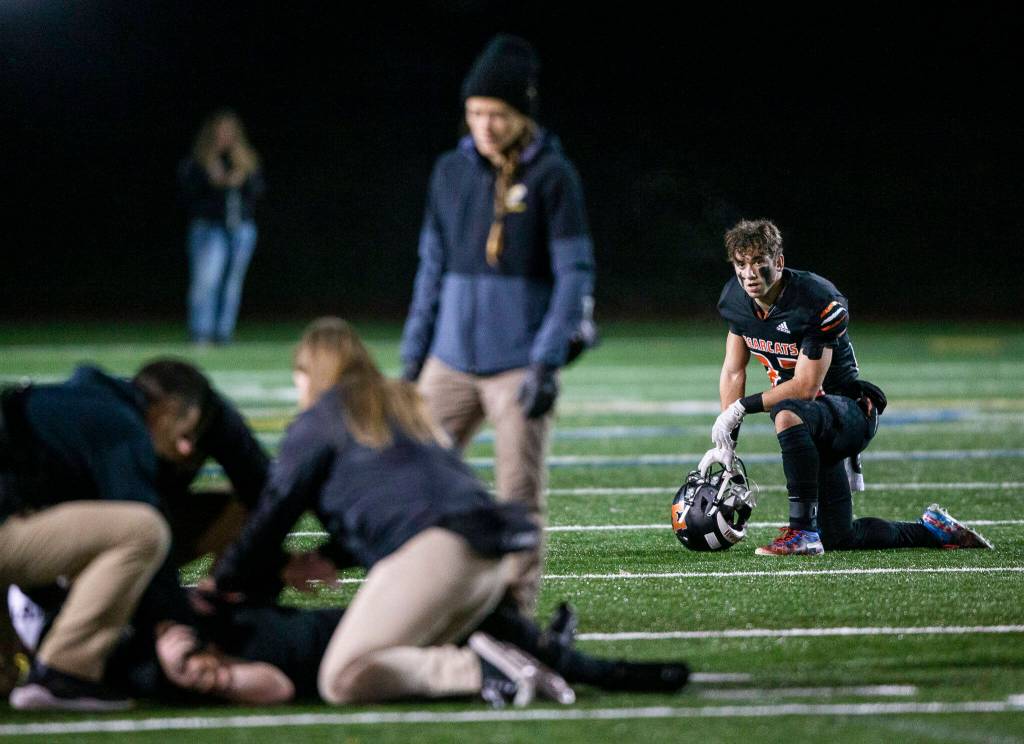 A Monroe player watches as his teammate gets evaluated for an injury during the game against Ferndale on Friday, Oct. 28, 2022 in Monroe, Washington. (Olivia Vanni / The Herald)