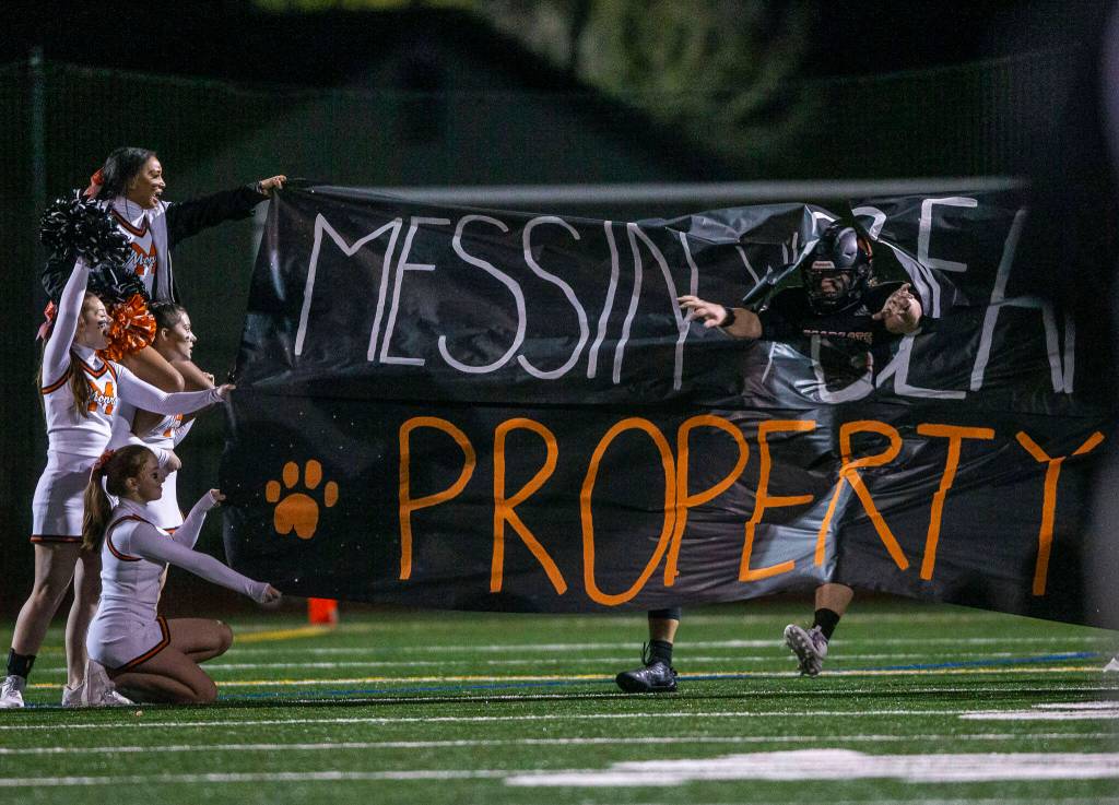 A Monroe player breaks through a banner during halftime at the game against Ferndale on Friday, Oct. 28, 2022 in Monroe, Washington. (Olivia Vanni / The Herald)