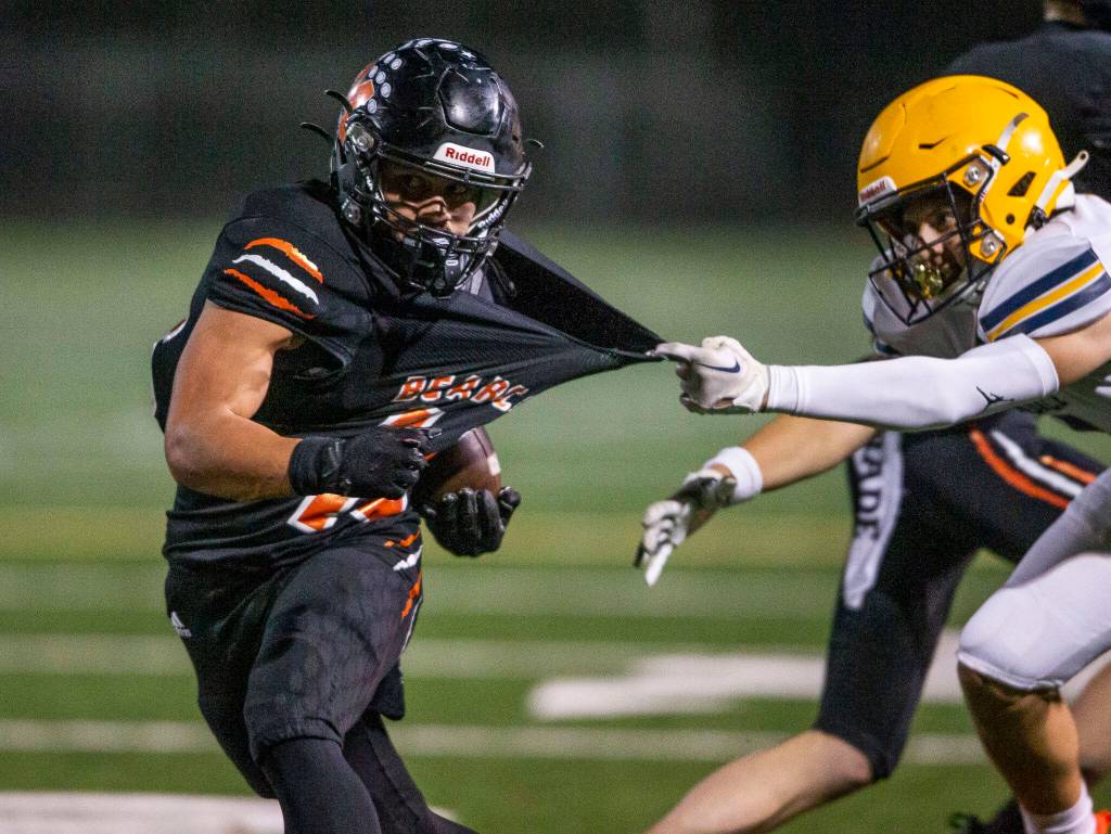 Monroes Beau Pruett has his jersey grabbed by a Ferndale player while running the ball during the game against Ferndale on Friday, Oct. 28, 2022 in Monroe, Washington. (Olivia Vanni / The Herald)