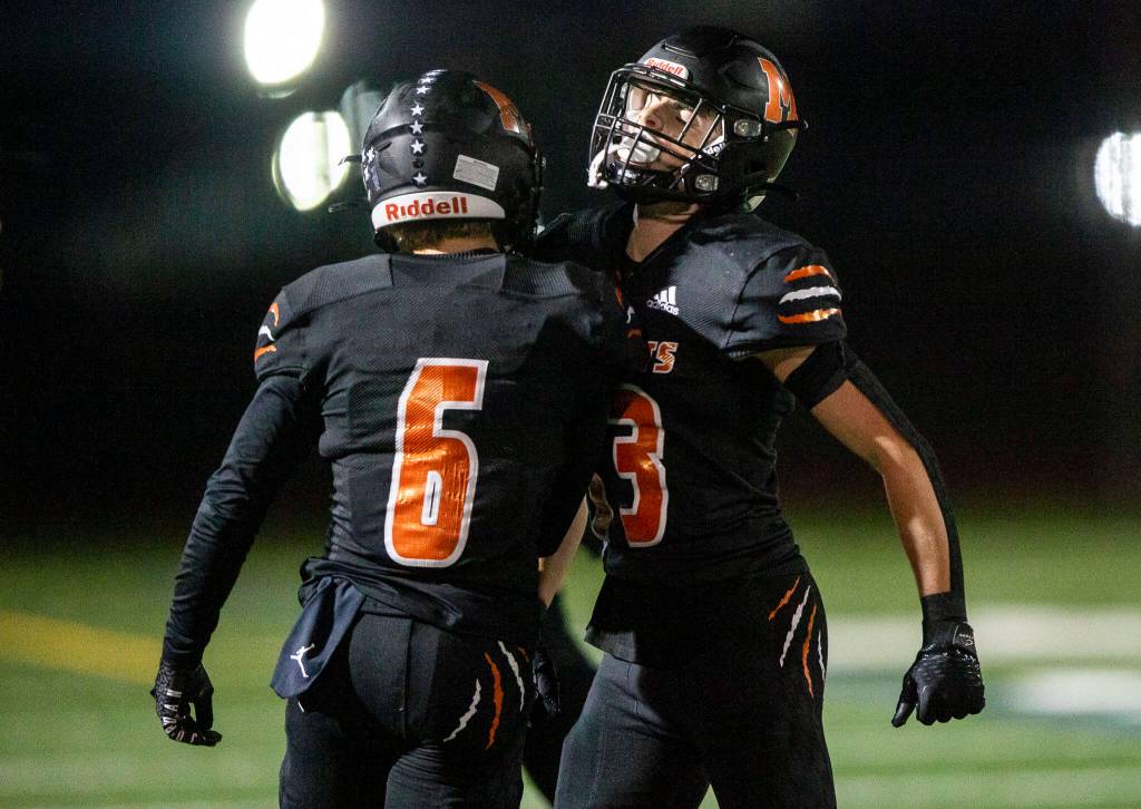 Monroes Eli Miller and Deegan Chapman celebrate a play during the game against Ferndale on Friday, Oct. 28, 2022 in Monroe, Washington. (Olivia Vanni / The Herald)