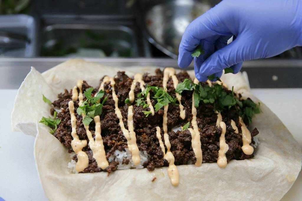 A kalbi steak burrito is garnished at Ryans REZ-ipes. (Kevin Clark / The Herald)