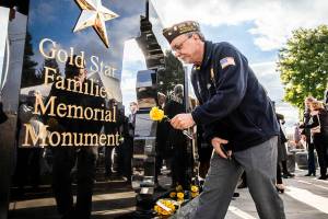 Air Force veteran Rick Holland places a yellow rose at the base of the new Gold Star Families Memorial Monument on Wednesday, Nov. 2, 2022 in Lynnwood, Washington. (Olivia Vanni / The Herald)