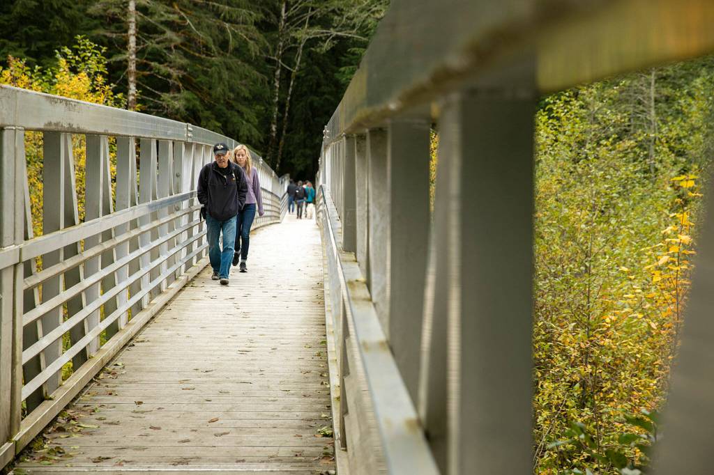 Hikers come and go along the repaired bridge over the South Fork of the Stillaguamish River on the Big Four Mountain Trail on Oct. 28, in Mount Baker-Snoqualmie National Forest near Granite Falls. (Ryan Berry / The Herald)
