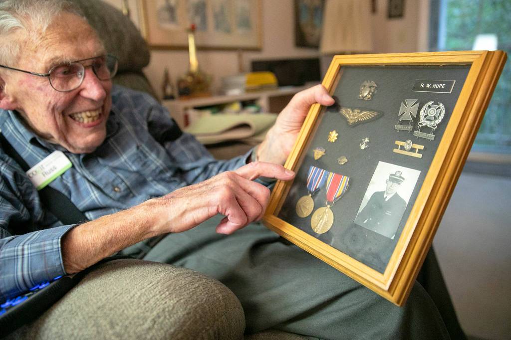 WWII veteran Russ Hupe shows off a display of his honors earned during his years in the armed forces on Nov. 3, at his home at Cogir Senior Living in Mill Creek. (Ryan Berry / The Herald)