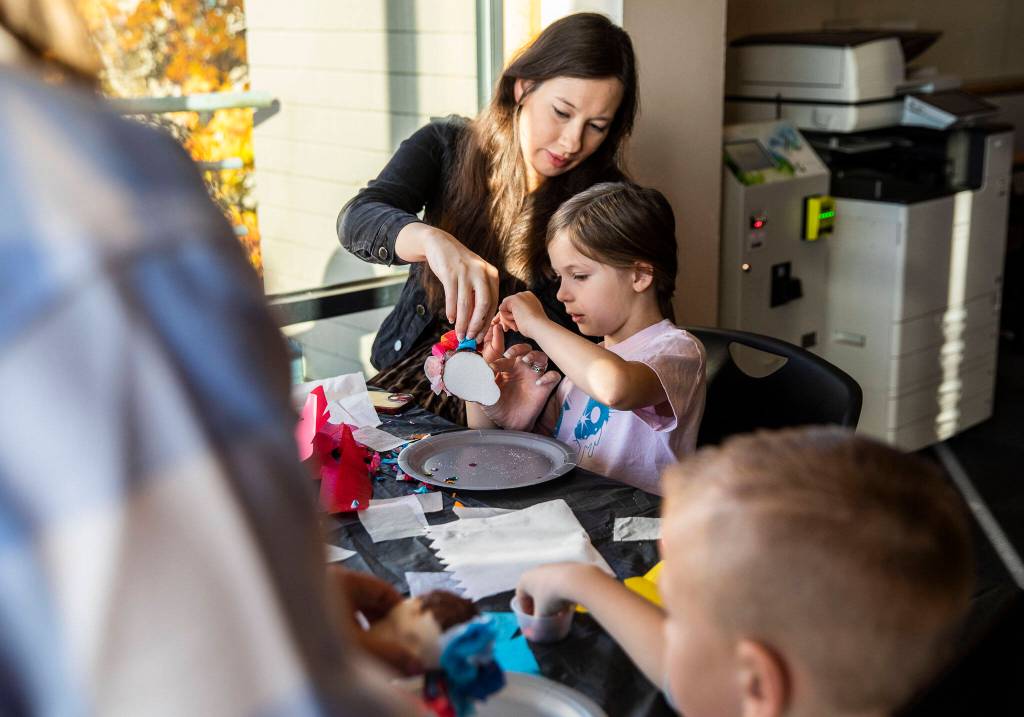 Anysia Snow, 6, and her mother Alex Snow work on decorating a sugar skull together during a free sugar skull making workshop at the Edmonds Library on Tuesday, in Edmonds. (Olivia Vanni / The Herald)