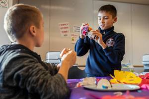 August Fisher, 9, right, and brother Alex Fisher, 8, left, work on decorating their sugar skulls during a free workshop with at the Edmonds Library on Tuesday, Nov. 1, 2022 in Edmonds, Washington. (Olivia Vanni / The Herald)
