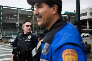 Officer Davis, left, and Officer Bernardi, right, wait for the light to change on the corner of Hewitt Avenue and Hoyt Avenue as the walk through downtown Everett on Thursday, Feb. 13, 2020. Everett's mayor and police chief have plans to hire 24 additional police officers by 2024. They will be patrol cops, bolstering the police department's visible presence in the community. (Olivia Vanni / The Herald)