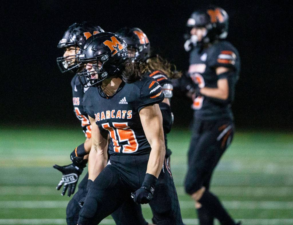 Junior Nick Mouser (15) and his Monroe teammates celebrate a stop on fourth down during the game against Ferndale on Oct. 28 in Monroe. Mouser and the Bearcats face Liberty (Renton) on Friday. (Olivia Vanni / The Herald)