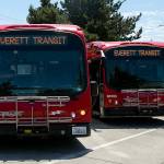 Officials gather outside two of Everett’s electric buses to discuss the new BattGenie system on Monday, June 27, 2022, at the Everett Transit bus yard in Everett, Washington. (Ryan Berry / The Herald)