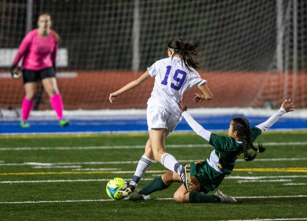 Shorecrests Tayvi Khann slide tackles Oak Harbors Madeline Mays during game on Tuesday, Nov. 1, 2022 in Shoreline, Washington. (Olivia Vanni / The Herald)