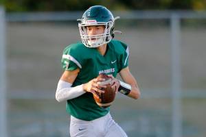 Edmonds-Woodway’s Steven Warren Jr. rolls out of the pocket while looking to pass against Monroe on Friday, Oct. 14, 2022, at Edmonds School District Stadium in Edmonds, Washington. (Ryan Berry / The Herald)