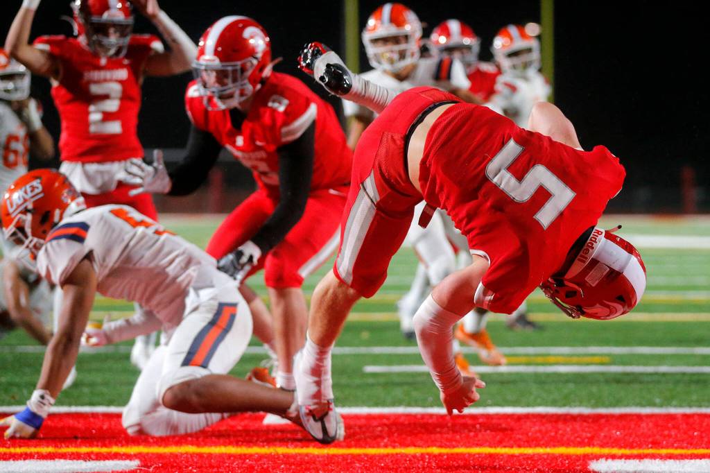 Stanwoods Ryder Bumgarner does a front flip into the end zone on a short touchdown run against Lakes High School on Friday, Nov. 4, 2022, at Stanwood High School in Stanwood, Washington. (Ryan Berry / The Herald)