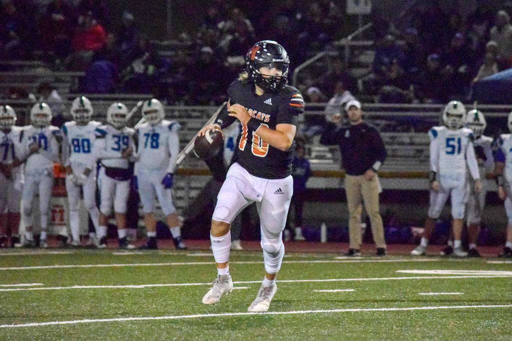Monroe junior quarterback Blake Springer looks for an open receiver on Friday, Nov. 4, 2022 in Monroe, Washington. (Katie Webber / The Herald)