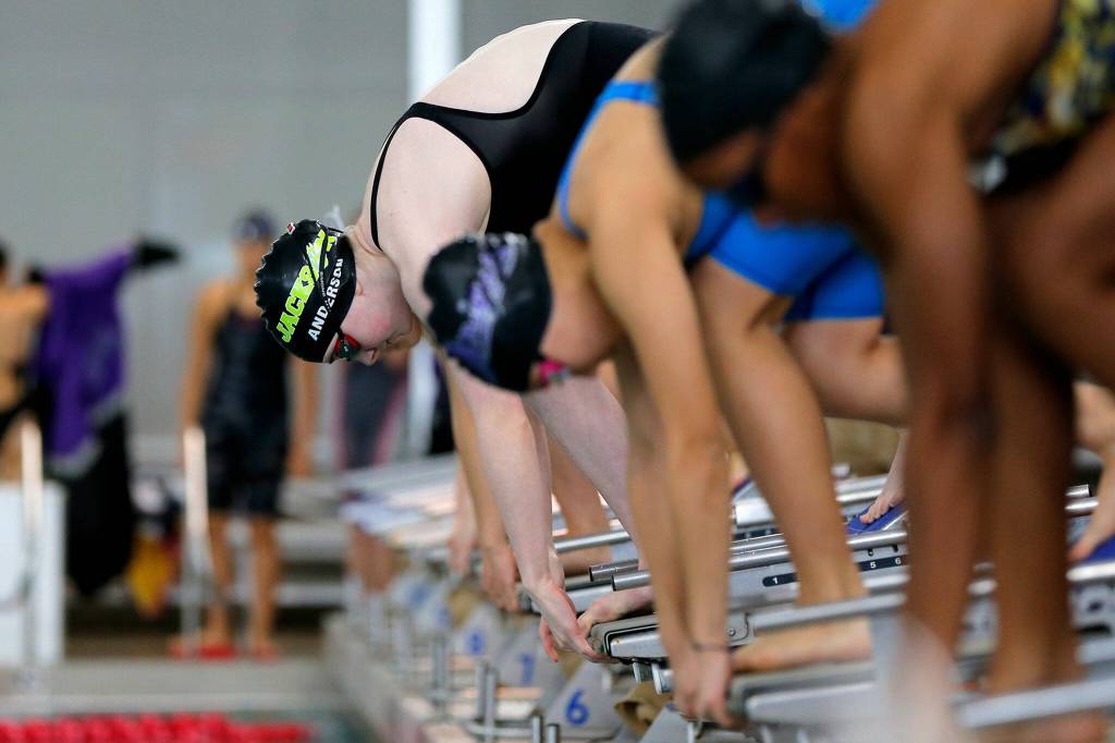 Swimmers in the 200 yard freestyle relay prepare to start the race during the Class 4A District 1 swim meet Saturday, Nov. 5, 2022, at Snohomish Aquatic Center in Snohomish, Washington. (Ryan Berry / The Herald)