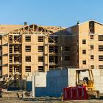 Builders on Tuesday work on the roof of one of the buildings that compose the Four Corners Apartments on Beverly Lane near Evergreen Way and 79th Place SE in Everett. DevCo, the real estate company creating the apartments, is receiving a $1 million state grant from the city of Everett. (Ryan Berry / The Herald)