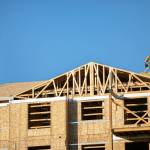 A construction worker walks on the roof of the Four Corners Apartments on Tuesday at 79th Place SE and Evergreen Way in Everett. (Ryan Berry / The Herald)