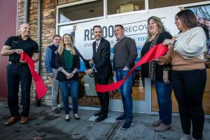 Marysville Mayor Jon Nehring cuts the ribbon at the open house for the Reboot Recovery on Monday, Nov. 14, 2022 in Marysville, Washington. (Olivia Vanni / The Herald)
