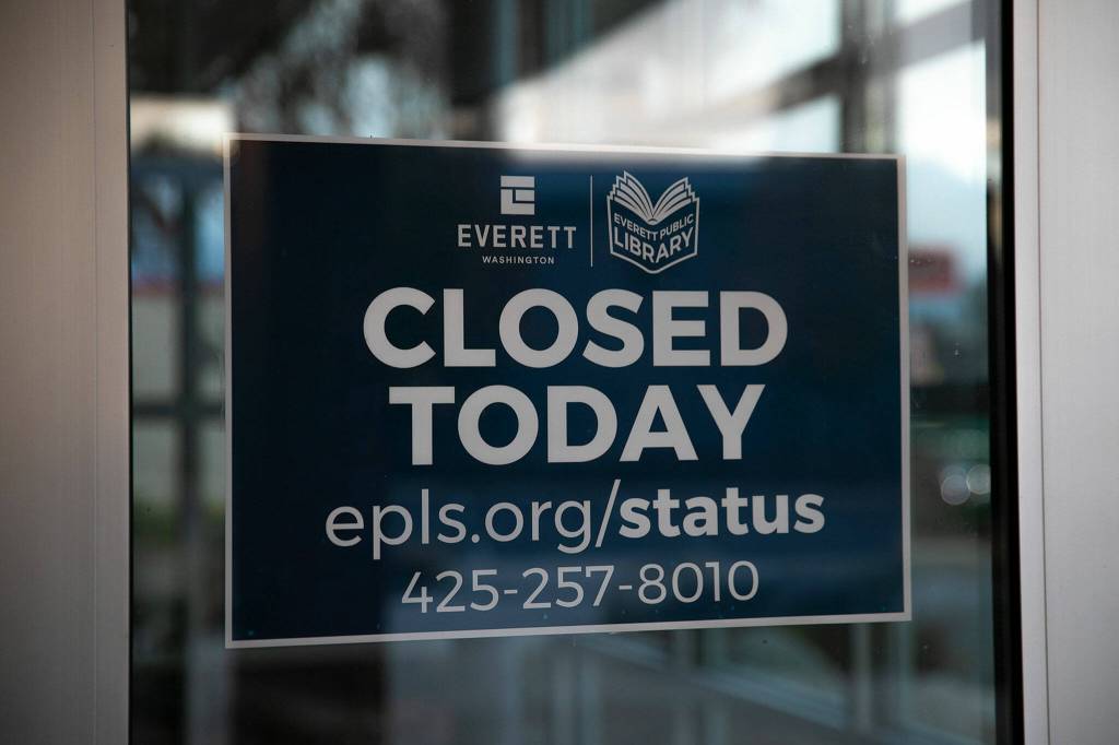 A closed sign is posted inside the front doors at the Evergreen Branch of the Everett Public Library on Friday, in Everett. (Ryan Berry / The Herald)