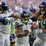 Seahawks running back Kenneth Walker III (middle) is congratulated by tight end Noah Fant (left) and tight end Colby Parkinson after scoring against the Cardinals during the second half of a game on Nov. 6 in Glendale, Ariz. (AP Photo/Matt York)
