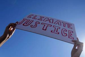 A demonstrator holds a sign reading "climate justice" at a Fridays for Future protest calling for money for climate action at the COP27 U.N. Climate Summit, Friday, Nov. 11, 2022, in Sharm el-Sheikh, Egypt. (AP Photo/Peter Dejong)