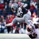 Washington State running back Nakia Watson (25) leaps and is tripped up by Arizona State defensive back Chris Edmonds (5) during the first half of a game Saturday in Pullman. (AP Photo/Young Kwak)