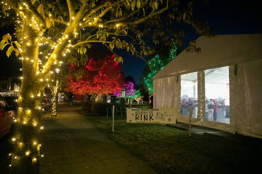 Lights glow outside Arlingtons new seasonal ice rink Friday at Legion Memorial Park. (Ryan Berry / The Herald)