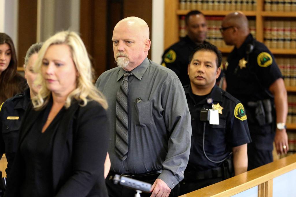 William Talbott II (center) is escorted to his seat at the Snohomish County Courthouse in Everett on June 28, 2019. Talbott was found guilty of the murder of Jay Cook and Tanya Van Cuylenborg. (Kevin Clark / Herald file)