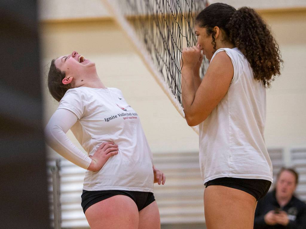 Charlie Thomas, left, and Hannah Johnson, right, laugh together before the start of a drill during practice on Tuesday, Nov. 15, 2022 in Bothell, Washington. (Olivia Vanni / The Herald)
