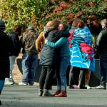 Parents comfort each other outside of Ingraham High School after reports of a school shooting in Seattle, on Tuesday, Nov. 8, 2022. A student who was shot at the Seattle high school has died and a suspect is in custody, officials said. (Greg Gilbert/The Seattle Times via AP)