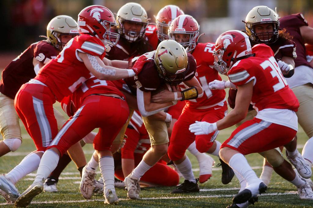 Stanwoods defense swarms Lakewood quarterback Nash Espe during a game Sept. 2 at Lakewood High School in Arlington. (Ryan Berry / The Herald)