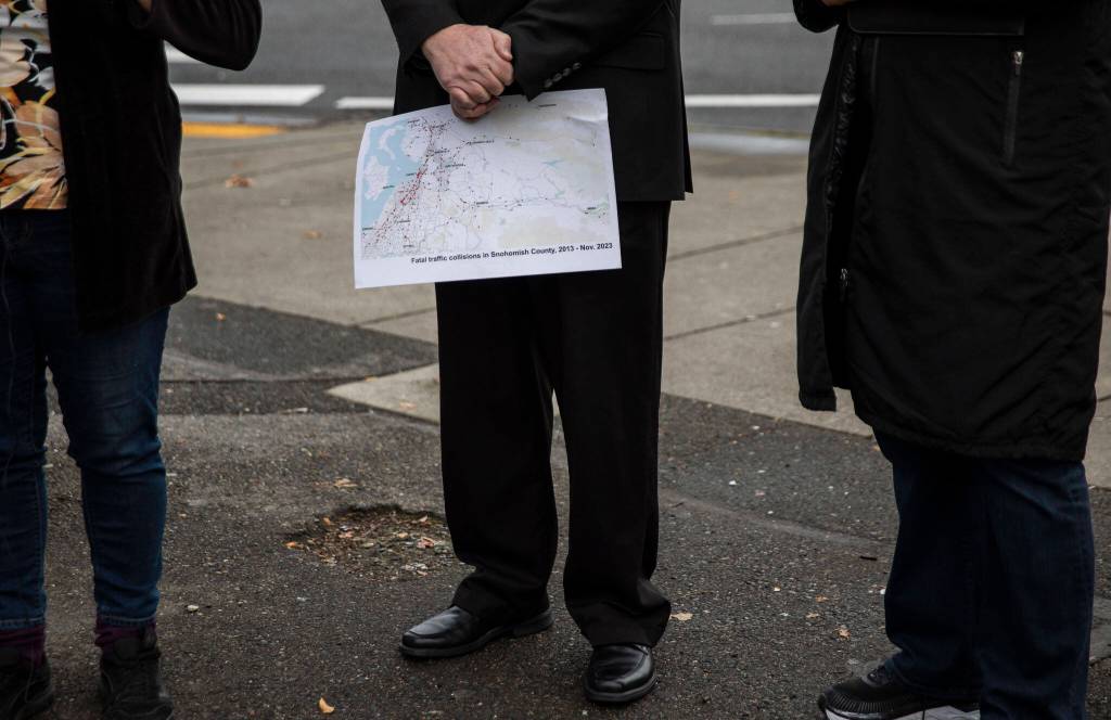 Lynnwood City Council member George Hurst holds a map marking fatal traffic collisions in Snohomish County since 2013 during a press conference for World Day of Remembrance for Road Traffic Victims on Monday in Everett. (Olivia Vanni / The Herald)