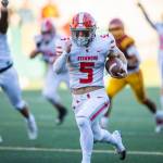 Stanwoods Ryder Bumgarner breaks away and runs the ball in for a touchdown while his teammates raise their arms and cheer during the 3A quarterfinal game against Odea on Saturday, Nov. 19, 2022 in Seattle, Washington. (Olivia Vanni / The Herald)