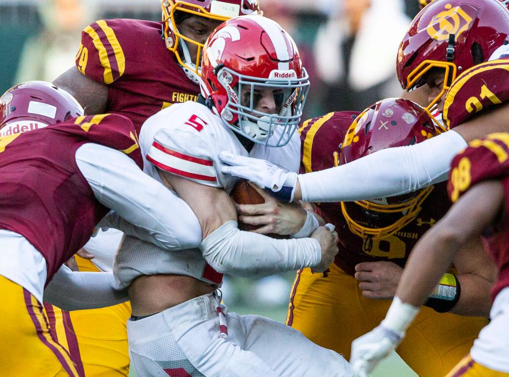 Stanwoods Ryder Bumgarner is tackled by multiple players while running the ball during the 3A quarterfinal game against Odea on Saturday, Nov. 19, 2022 in Seattle, Washington. (Olivia Vanni / The Herald)