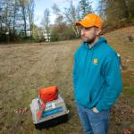 Jeff Brown, wildlife naturalist with PAWS, watches as a rehabilitated red-tailed hawk he released flies to a tree and pesters some crows Wednesday, Nov. 23, 2022, at Evergreen Cemetery in Everett, Washington. (Ryan Berry / The Herald)