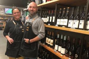 Krista and Eric Brown are the owners of The Grape & Grain bottle shop in Everett. (Jon Bauer / The Herald