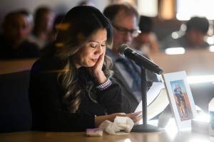 Sunlight illuminates a framed photograph of Mila and Wilfrido Sarmiento while their daughter Rowella Sarmiento cries reading her statement to the court during Caleb Wride’s sentencing on Monday, Nov. 28, 2022 in Everett, Washington. (Olivia Vanni / The Herald)