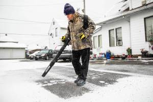 Robert Miller blows snow out of the parking lot next to his home as snow comes down on Tuesday, Nov. 29, 2022 in Everett, Washington. (Olivia Vanni / The Herald)
