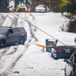 A Mountlake Terrace police officer blocks off a street with a live wire downed by a tree branch along 66th Avenue West on Wednesday, Nov. 30, 2022 in Mountlake Terrace, Washington. (Olivia Vanni / The Herald)