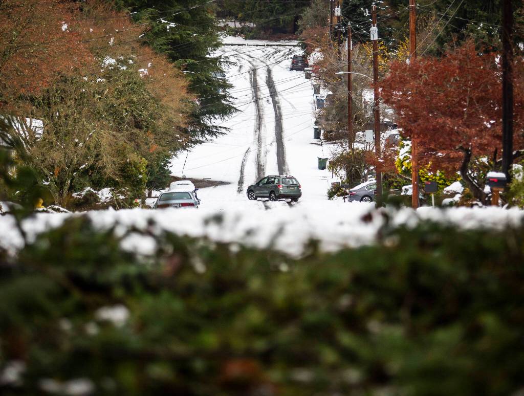 A car turns around on 216th Street Southwest after seeing downed branches covering the roadway on Wednesday, Nov. 30, 2022 in Edmonds, Washington. (Olivia Vanni / The Herald)
