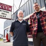 Father-and-son Mike and David Lane stand in front of Everett Vacuum on Broadway with their popular sign and saying, Everything we sell sucks. In November, the store moved to Hewitt Avenue, where overhang signs arent allowed, so a new flat banner with the sucks saying was made for the front window. (Olivia Vanni / The Herald)