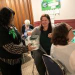 Members of 100+ Women Who Care About Snohomish County put their votes in a basket during their Giving Circle meeting at the Sons of Norway Normanna Lodge in Everett. (Ryan Berry / The Herald)